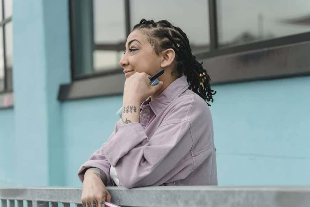 Happy woman with hand at chin on street